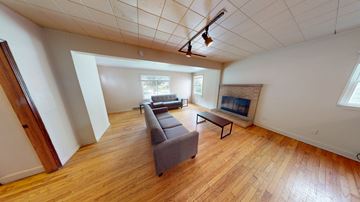 Ann Arbor apartment for rent - A living room with a grey couch and a wooden floor.