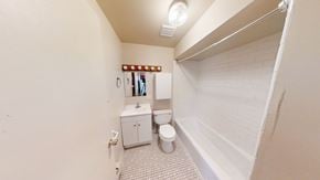 Ann Arbor apartment for rent - A small bathroom with a toilet, sink, and a mirror.