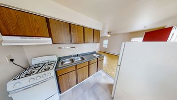 Ann Arbor apartment for rent - A kitchen with a white stove and wooden cabinets.