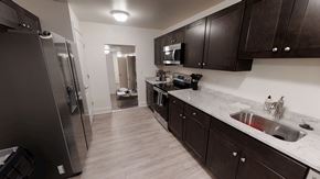 Ann Arbor apartment for rent - A kitchen with dark wood cabinets and a stainless steel refrigerator.
