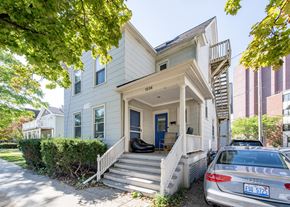 Ann Arbor apartment for rent - A silver car is parked in front of a two-story house.