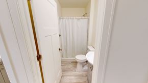 Ann Arbor apartment for rent - A white bathroom with a toilet and a shower curtain.