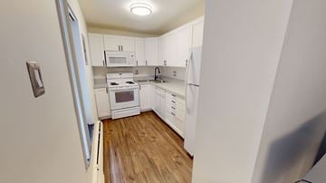 Ann Arbor apartment for rent - A kitchen with white cabinets and a wooden floor.