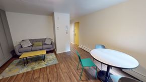 Ann Arbor apartment for rent - A living room with a grey couch, yellow coffee table, and a green chair.