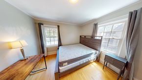 Ann Arbor apartment for rent - A bedroom with a bed, nightstand, and window.
