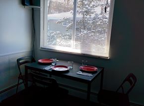 Ann Arbor apartment for rent - A table with two chairs and a meal set up by a window.