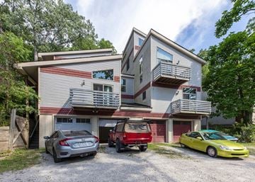 Ann Arbor apartment for rent - A two-story house with a garage and three cars parked in front.