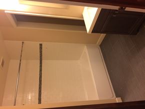 Ann Arbor apartment for rent - A shower with a white tiled wall and a silver shower head.