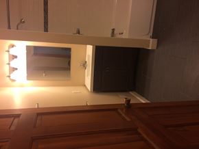 Ann Arbor apartment for rent - A wooden bench is in front of a mirror in a room.