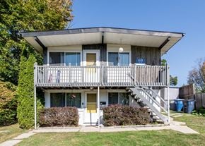 Ann Arbor triplex for rent - A two-story house with a balcony and stairs leading to the second floor.