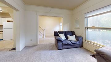 Ann Arbor apartment for rent - A living room with a blue couch and a grey carpet.