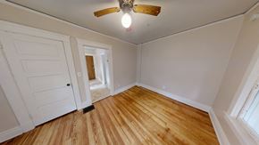 Ann Arbor apartment for rent - A room with a ceiling fan and wooden flooring.