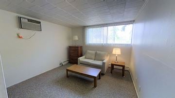 Ann Arbor apartment for rent - A living room with a couch, a lamp, and a table.