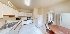 Ann Arbor apartment for rent - A kitchen with white cabinets and a wooden table.