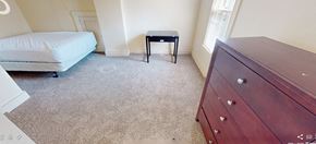 Ann Arbor apartment for rent - A bedroom with a bed, a small table, and a dresser.