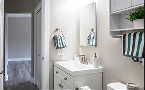 Ann Arbor apartment for rent - A white bathroom with a toilet, sink, and mirror.