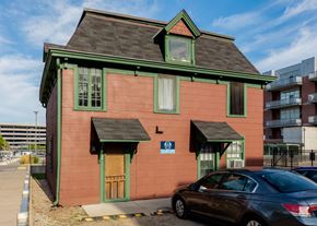 Ann Arbor apartment for rent - A red building with green trim and a car parked in front.