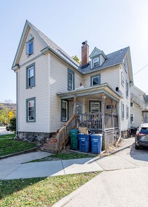 Ann Arbor apartment for rent - A two-story house with a front porch and a car parked in front.