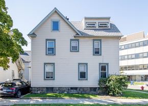 Ann Arbor apartment for rent - A house with a grey facade and a black car parked in front.