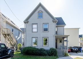 Ann Arbor apartment for rent - A two-story house with a grey exterior and a small front porch.