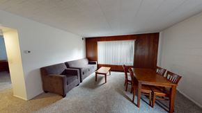 Ann Arbor apartment for rent - A living room with a brown couch, a brown chair, and a brown table.