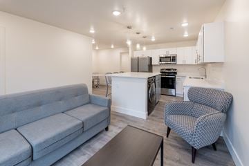 Ann Arbor apartment for rent - A grey couch sits in a living room with a black coffee table in front of it.