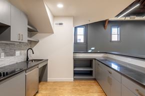 Ann Arbor apartment for rent - A modern kitchen with a stainless steel dishwasher and wooden floors.