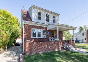 Ann Arbor triplex for rent - A small house with a red brick wall and a white section on top.