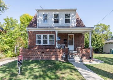 Ann Arbor triplex for rent - A house with a red brick facade and a white porch.
