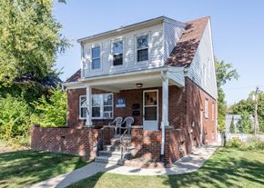 Ann Arbor triplex for rent - A house with a red brick wall and a white porch.