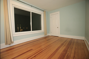 Ann Arbor apartment for rent - A room with a wooden floor and a window with curtains.