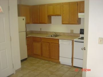 Ann Arbor apartment for rent - A kitchen with wooden cabinets and white appliances.