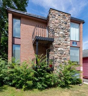 Ann Arbor apartment for rent - A red brick house with a balcony and a stone chimney.