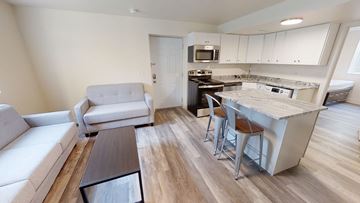 Ann Abor apartment for rent - A modern kitchen with white cabinets and a wooden island.