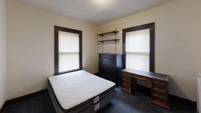 Ann Arbor apartment for rent - A bedroom with a bed, desk, and shelves.