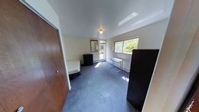 Ann Arbor apartment for rent - A room with a brown door, a black chair, and a white sofa.
