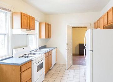 Ann Arbor apartment for rent - A kitchen with white appliances and wooden cabinets.