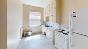 Ann Arbor apartment for rent - A white kitchen with a fridge, stove, and sink.
