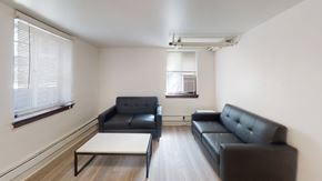 Ann Arbor apartment for rent - A black sofa sits in a white room with a coffee table in front of it.