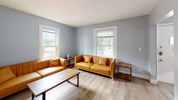 Ann Arbor apartment for rent - A living room with a yellow couch and a wooden coffee table.