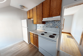 Ann Arbor triplex for rent - A kitchen with a white stove and wooden cabinets.
