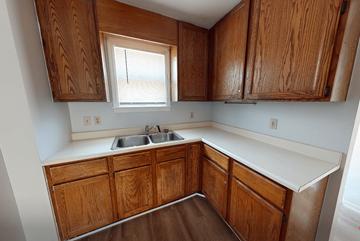 Ann Arbor triplex for rent - A kitchen with wooden cabinets and a window above the sink.