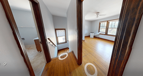 Ann Arbor triplex for rent - A room with wooden floors and white walls.
