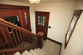 Ann Arbor apartment for rent - A wooden staircase with a carpeted runner and a chandelier hanging from the ceiling.