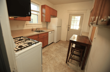 Ann Arbor apartment for rent - A kitchen with a white stove and wooden cabinets.