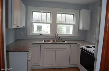 Ann Arbor apartment for rent - A kitchen with white cabinets and a granite countertop.