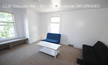 Ann Arbor apartment for rent - A living room with a blue chair and a white coffee table.