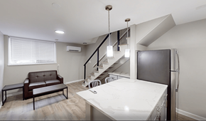 Ann Arbor apartment for rent - A modern kitchen with a brown leather sofa and a white countertop.