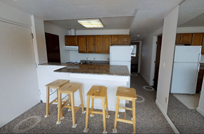 Ann Arbor apartment for rent - A kitchen with a white fridge and wooden stools.