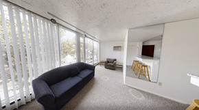 Ann Arbor apartment for rent - A living room with a couch, a chair, and a small kitchenette.